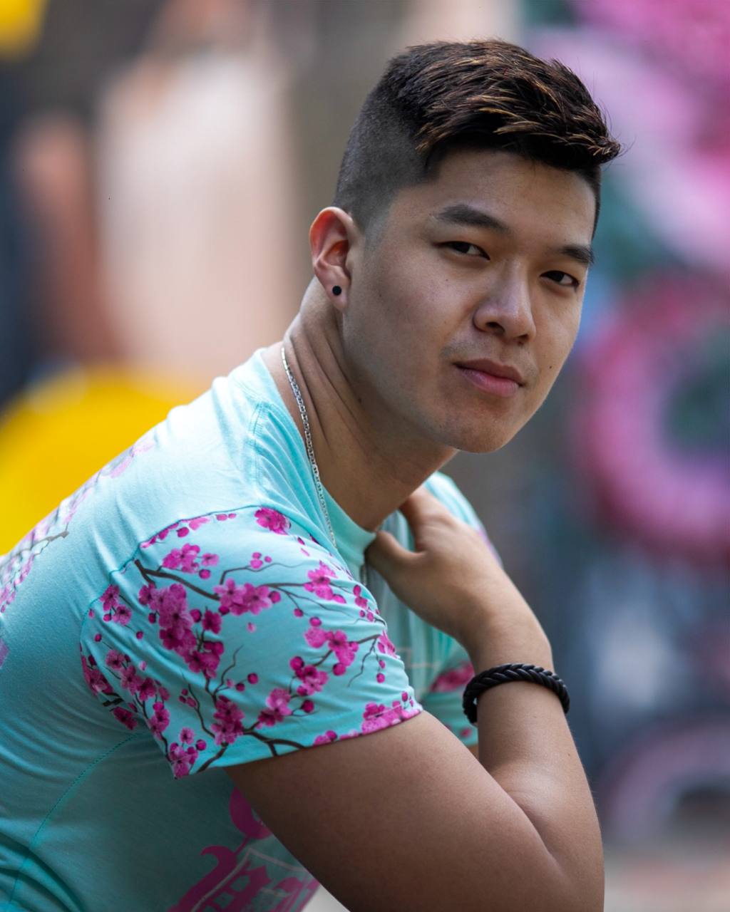 Colorful portrait of a young man against a mural.